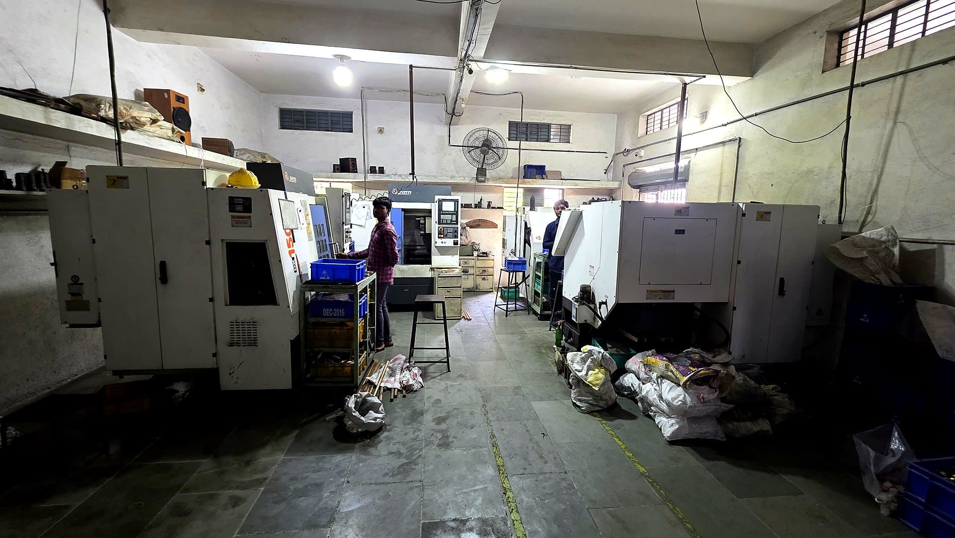 Workers operating CNC machines on the production floor